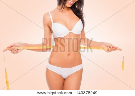 Pretty Girl In White Underwear Measuring Her Waist With Measuring Tape