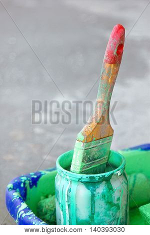 Dirty brush in a bank with green paint
