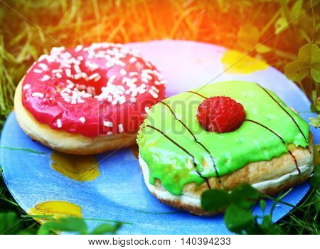 two dough nuts with mint and strawberry green and red glaze with candy and strawberry