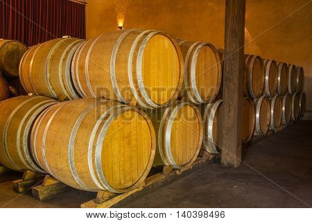 Wine barrels stacked in the old cellar of the winery.