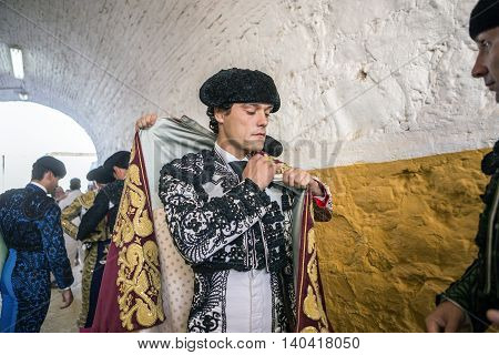 Andujar SPAIN - September 7 2014: Spainish bullfighter Miguel Abellan putting itself the walk cape in the alley before going out to bullfight typical and very ancient tradition in Andujar Spain