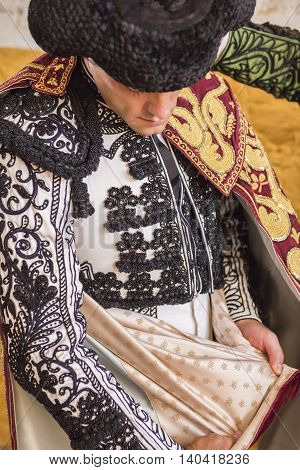 Andujar SPAIN - September 7 2014: Spainish bullfighter Miguel Abellan putting itself the walk cape in the alley before going out to bullfight typical and very ancient tradition in Andujar Spain