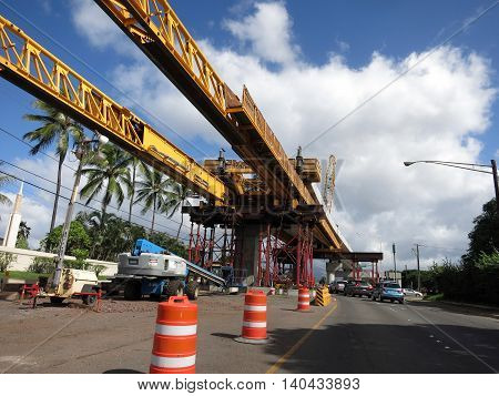 HONOLULU - NOVEMBER 29: HART Light Rail concrete guideway under construction in road center with machines in Pearlrigde on Oahu Hawaii on November 29 2015. HART is building a 8 billlion dollar railway linking Oahu communities.