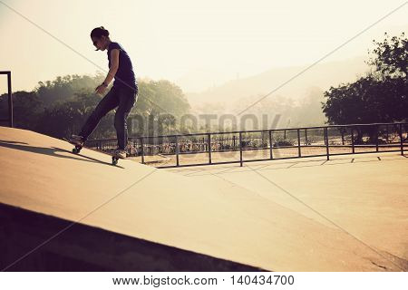 one young woman skateboarder skateboarding at skatepark