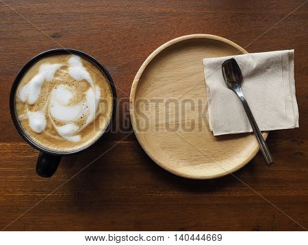Coffee tree time in restaurant. Hot cappuccino in black cup for wooden table.