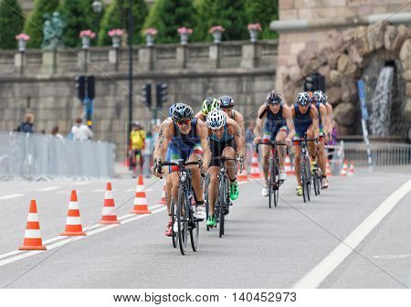 STOCKHOLM SWEDEN - JUL 02 2016: Group of colorful male triathlete cyclists Gregory Barnaby (ITA) and competitors the royal castle in background in the Men's ITU World Triathlon series event July 02 2016 in Stockholm Sweden