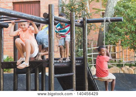 School kids playing on monkey rack at playground