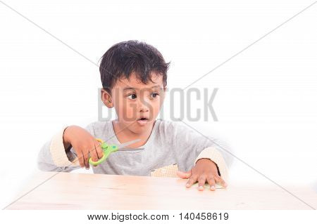 Boy play scissors cutting paper on white background
