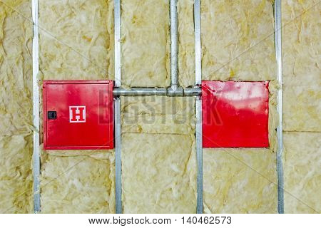 Front and back side of fire box with symbol for hydrant is in unfinished party wall.