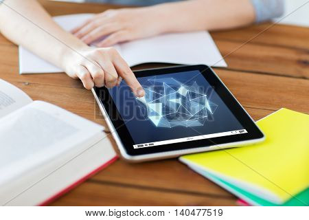 education, technology, network and internet concept - close up of student woman with low poly shape on tablet pc computer screen and notebook at home