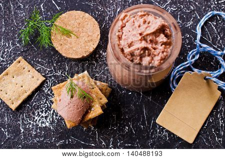 Liver pate with crisps on a dark background. Selective focus.