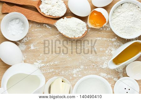 Ingredients for baking - flour eggs salt sugar butter milk. View from above. Rustic background with free text space. Ingredients for the dough. Food background