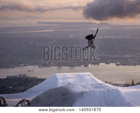 Freestyle skier performs backflip mute grab on jump over city