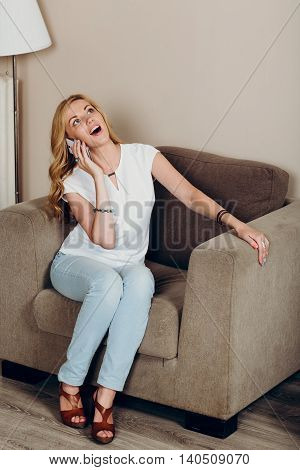 Positive smiling blond girl with mobile phone