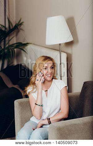 Positive smiling blond girl with mobile phone