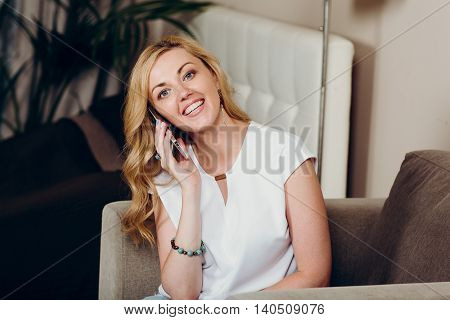 Positive smiling blond girl with mobile phone