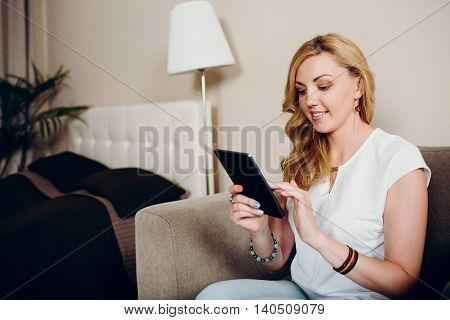 Positive smiling blond girl with tablet pc