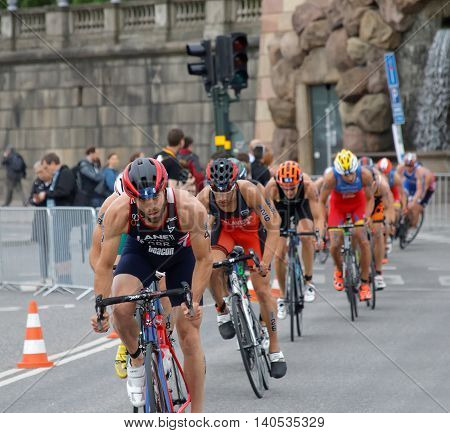 STOCKHOLM SWEDEN - JUL 02 2016: Group of colorful male triathlete cyclists Adam Bowden in the lead competitors behind in the Men's ITU World Triathlon series event July 02 2016 in Stockholm Sweden