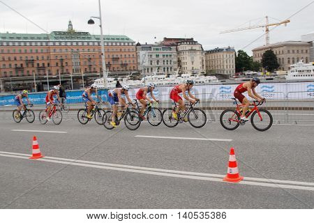 STOCKHOLM SWEDEN - JUL 02 2016: Group of colorful male triathlete cyclists on a bridge in the Men's ITU World Triathlon series event July 02 2016 in Stockholm Sweden
