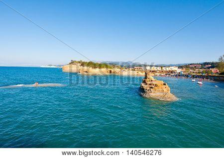 Famous Sidary beach holidaymakers sunbath on the a sandy shore. Corfu Greece.