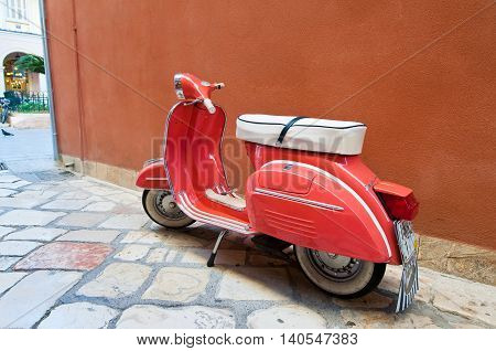 CORFU-AUGUST 22: Vintage Vespa scooter on Kerkyra street on August 22 2014 on Corfu island in Greece. Vespa is an Italian brand of scooter manufactured by Piaggio.