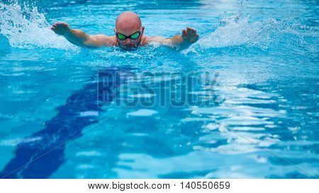 Athletic swimmer training in a swimming pool.