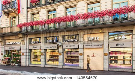Zurich, Switzerland - 30 July, 2016: a person, who looks as if being homeless is passing along windows of a store offering luxurious watches on Bahnhofstrasse street. Bahnhofstrasse is one of the world's most expensive shopping avenues.