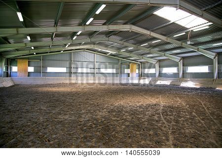 Riding hall with sandy covering without people