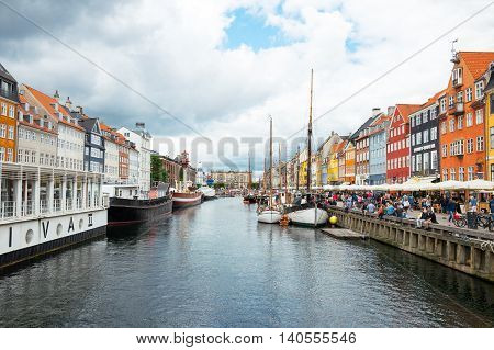 Copenhagen Denmark - July 20 2015: A crowd of tourists betveen the raditional houses and boats in the Nythavn canal
