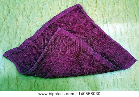 Folded dirty purple cloth on a marble table