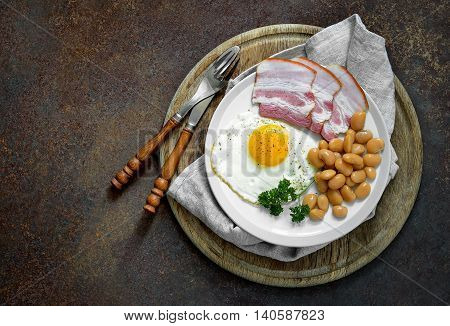 Traditional breakfast with fried egg beans and bacon