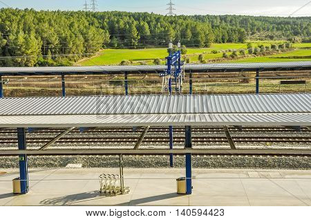 Platform of modern railway station Camp de Tarragona (Spain) with beautiful landscape. Horizontal.