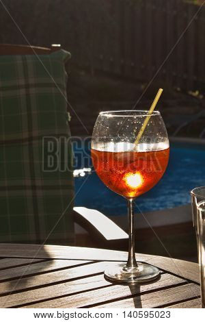 Cold summer drink by the pool. Party with refreshments by the pool. Alcohol drink with ice. Glasses with a refreshing drink. Alcohol at the party.