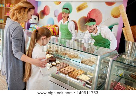 Obliging vendors serves customers in candy store 