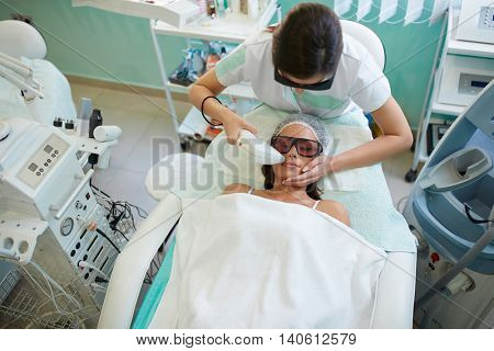 Laser hair removal in the beauty salon, woman having facial hair removal at cosmetic beauty spa clinic