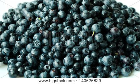 black forestry black berry berry blueberries on a wooden table in a white saucer gifts of nature