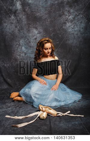 Ballerina Tying Ballet Shoes.Ballet dancer in blue skirt