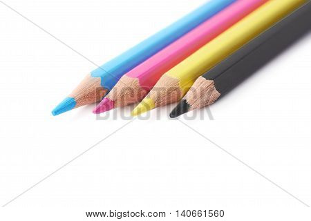 Four cmyk colored drawing pencils composition isolated over the white background, close-up crop
