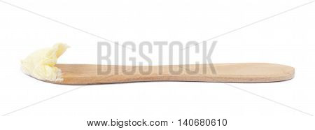 Wooden butterknife with a piece of butter over it, composition isolated over the white background