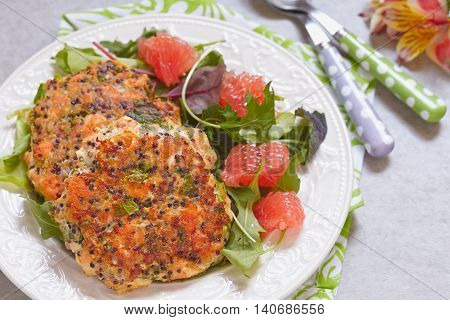 Healthy salmon quinoa kale burger with a green salad
