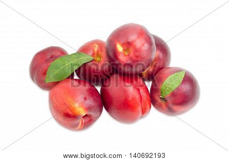 Several ripe fresh nectarines with leaves on a light background