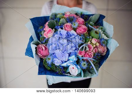 Big bouquet of white and blue flower in hands