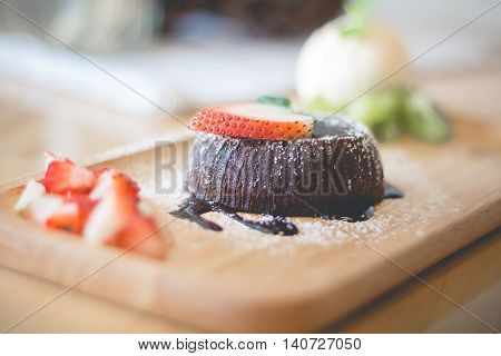 chocolate lava cake with vamilla ice cream and strawberry. Hot chocolate pudding with fondant centre.(selective focus)