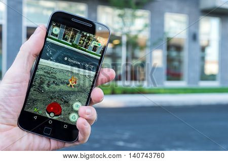 Montreal CA - July 27 2016: Closeup of a man playing Pokemon Go on a smart phone. Pokemon Go is a virtual reality game released in July 2016.