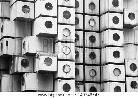 TOKYO, JAPAN - 22 JUNE 2016: The iconic Nakagin Capsule Tower in Shimbashi, Tokyo. Built in 1972 designed by Kisho Kurosawa and a rare surviving example of Japanese Metabolism style. Black and white.