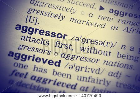 Aggressor word in English dictionary. Clos-up shot.