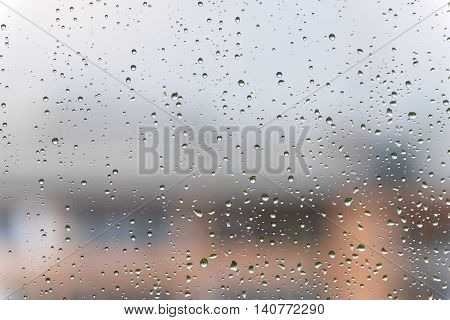 Real rain drops on the window on a rainy summer day.