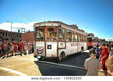 KALISPELL, MONTANA - JULY 4, 2016: Trolley cars from the Montana Trolley Company in Kalispell drive down Main Street during 4th of July Parade.