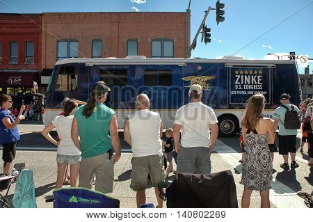 KALISPELL, MT, USA - JULY 4 : Campaign bus of US Representative Ryan Zinke (R-MT) drives in 4th of July Parade on Main Street in Kalispell, Montana, on July 4, 2016, as a crowd of spectators watches. 