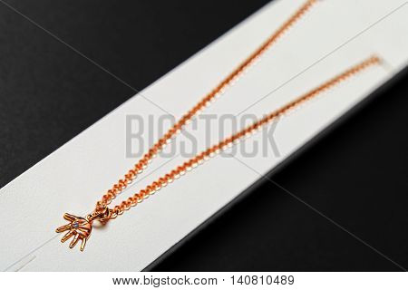 gold chainlet with a pendant hand isolated on a black background